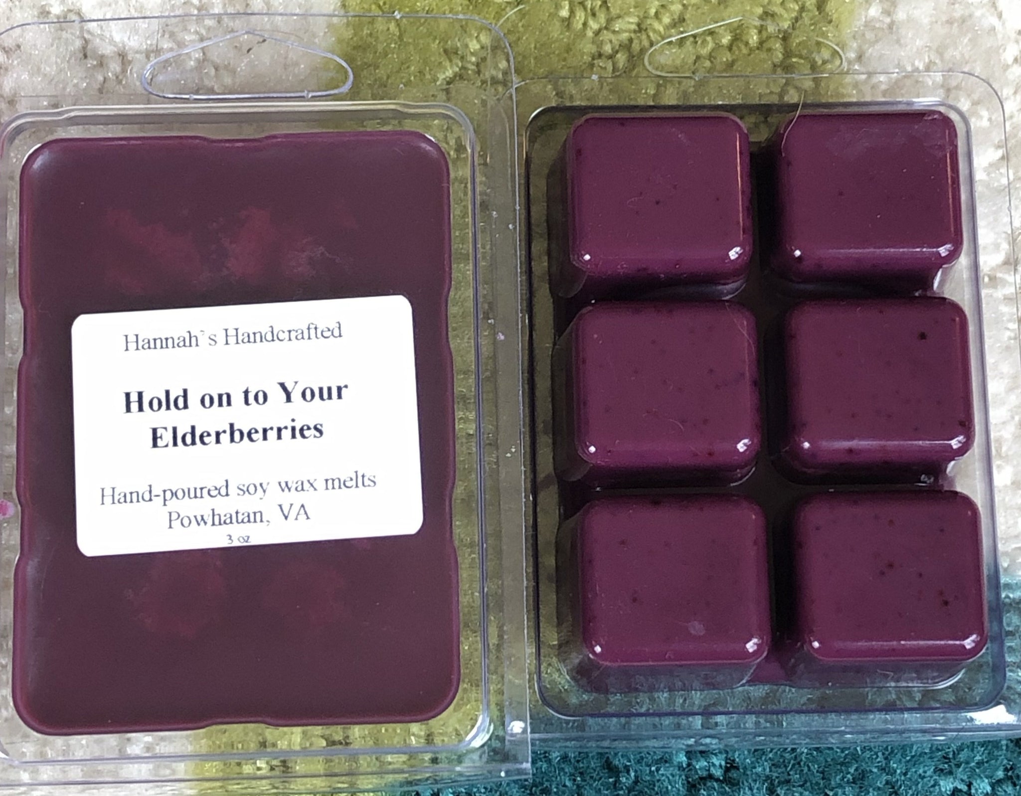 Two cases of wax melts. There are 6 melts in each container, both dark purple in color.